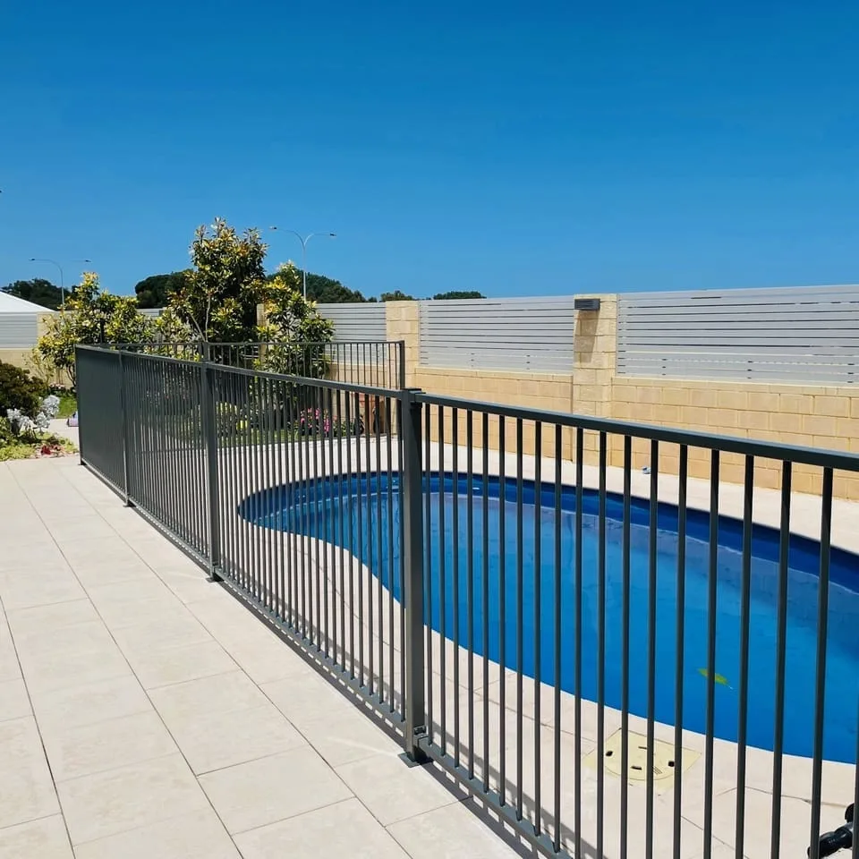 Black aluminium pool fence around a kidney-shaped pool
