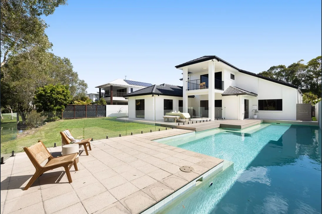 Frameless glass pool fence around a resort-style pool at a two-storey home
