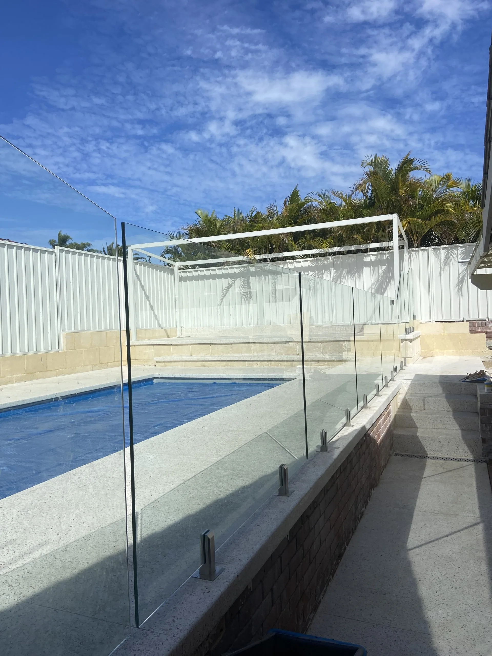 Frameless glass fencing along a raised pool edge