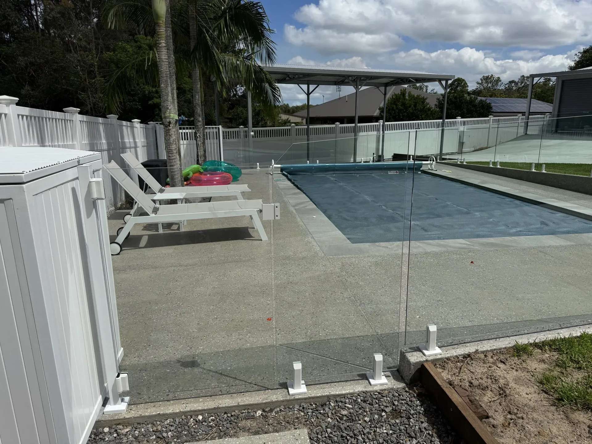 Frameless glass fence panels along a concrete pool surround