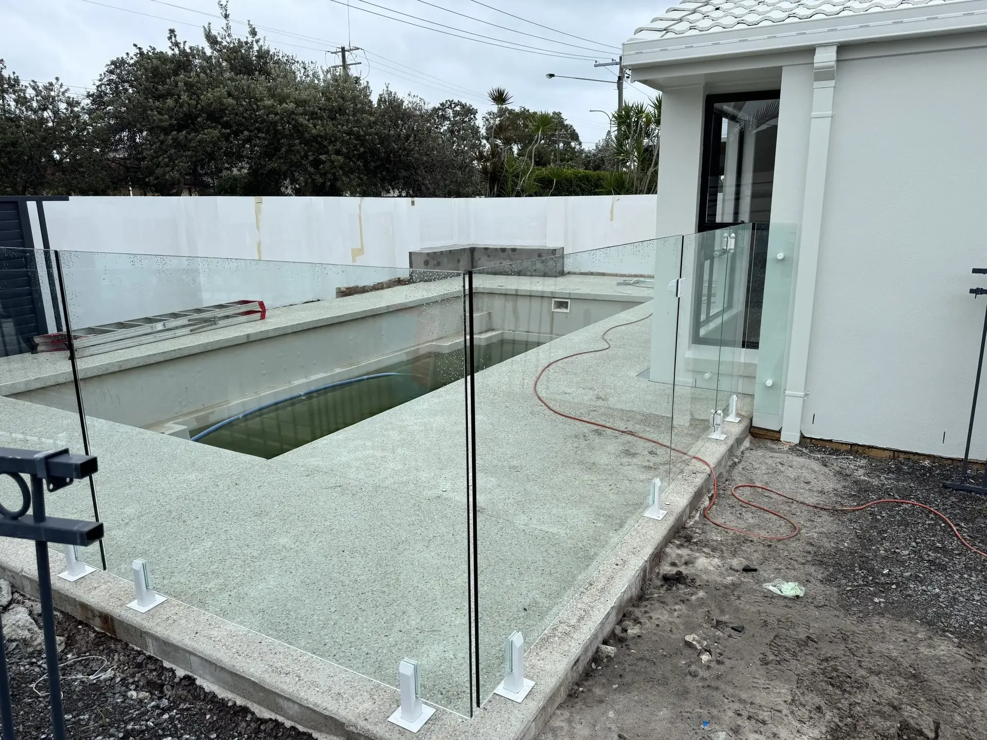 Glass pool fence panels around a pool under construction
