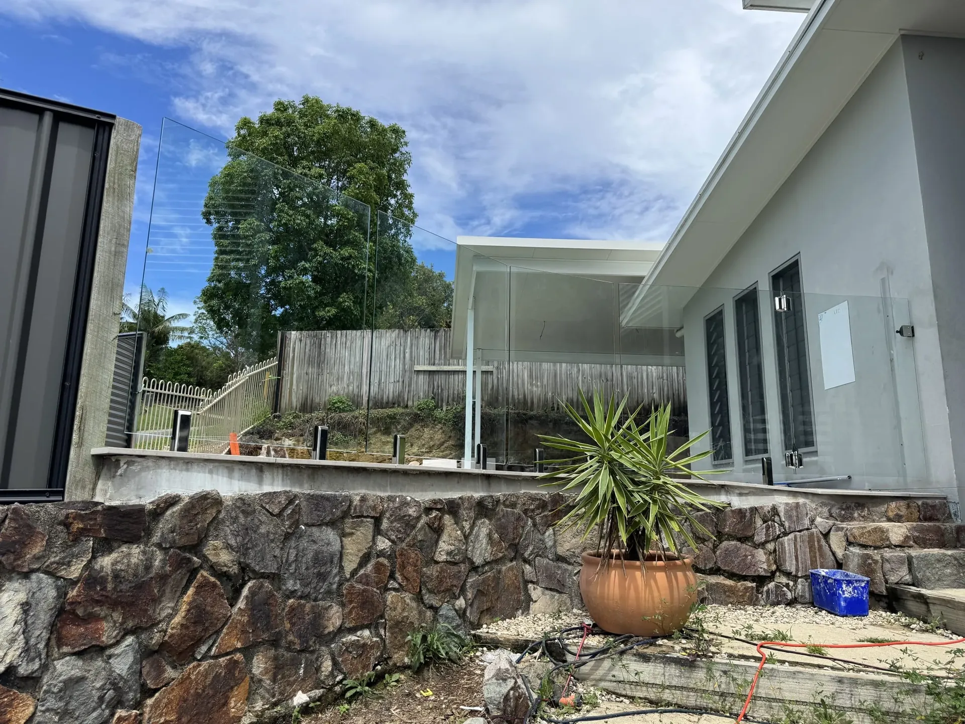 Pool area beside a rock retaining wall ready for fencing