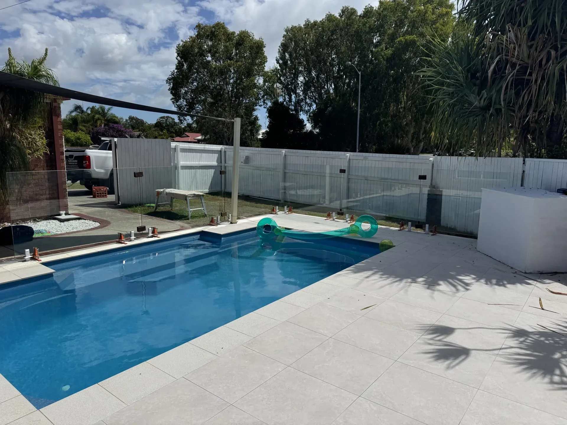 Glass pool fence along a paved pool surround