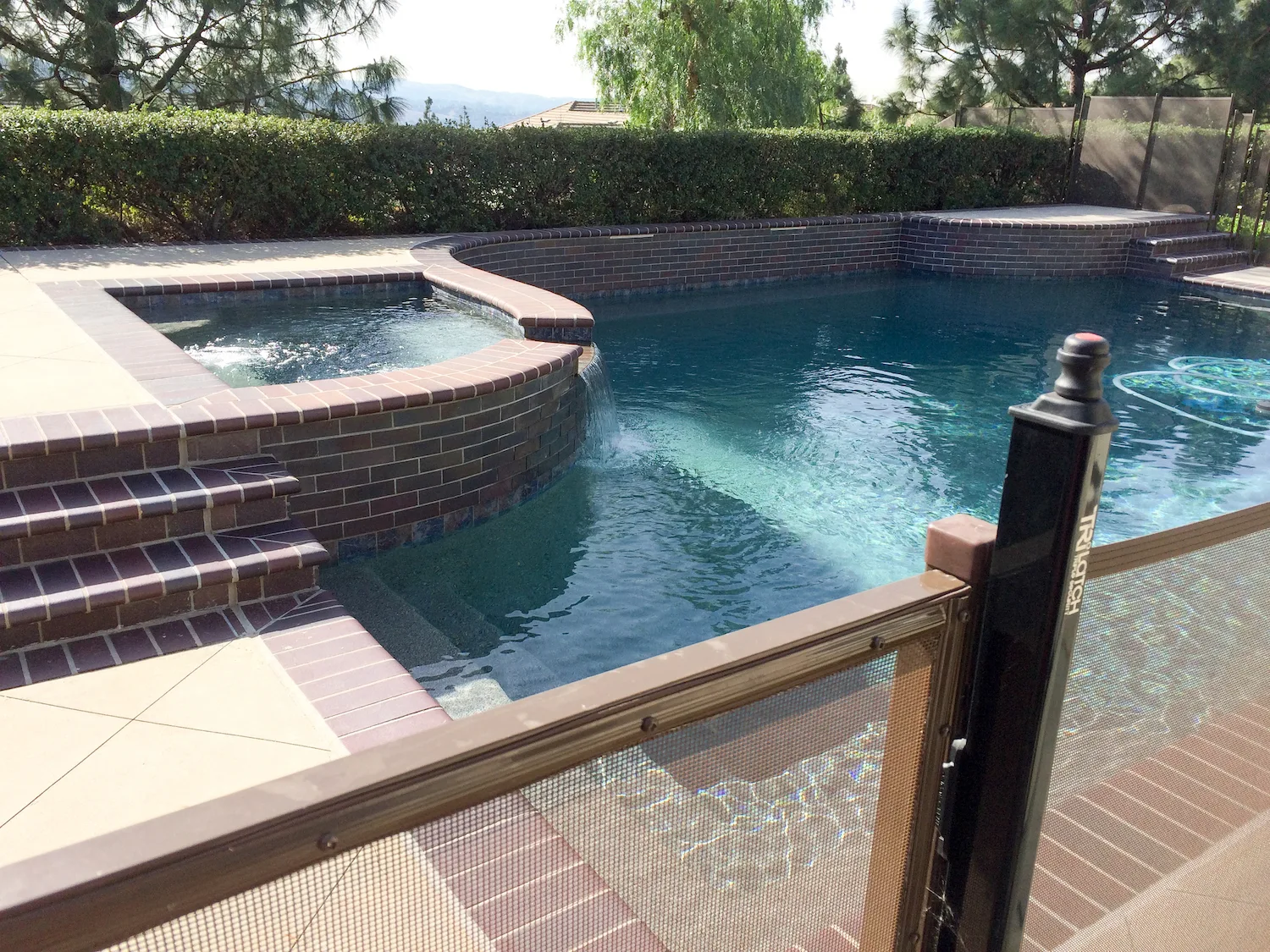 Pool fence gate beside a pool and spa